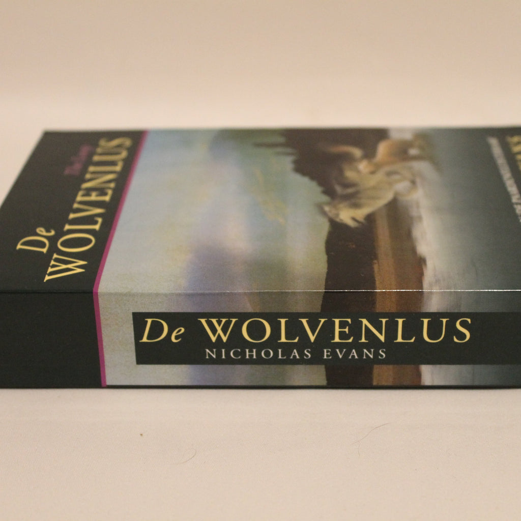 Book titled 'De Wolvenlus' by Nicholas Evans on a plain background