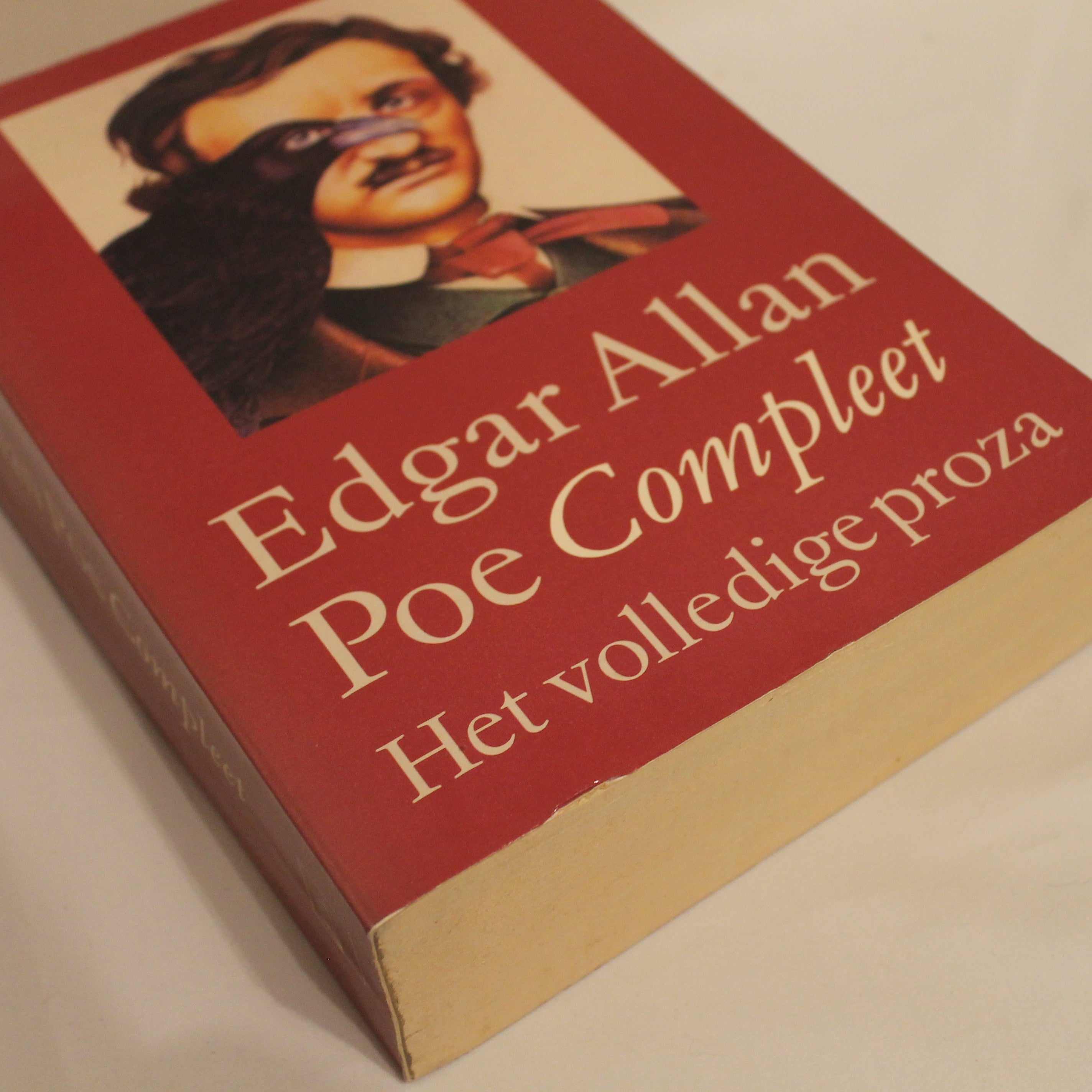 Book titled 'Edgar Allan Poe Compleet' with a portrait on the cover against a beige background