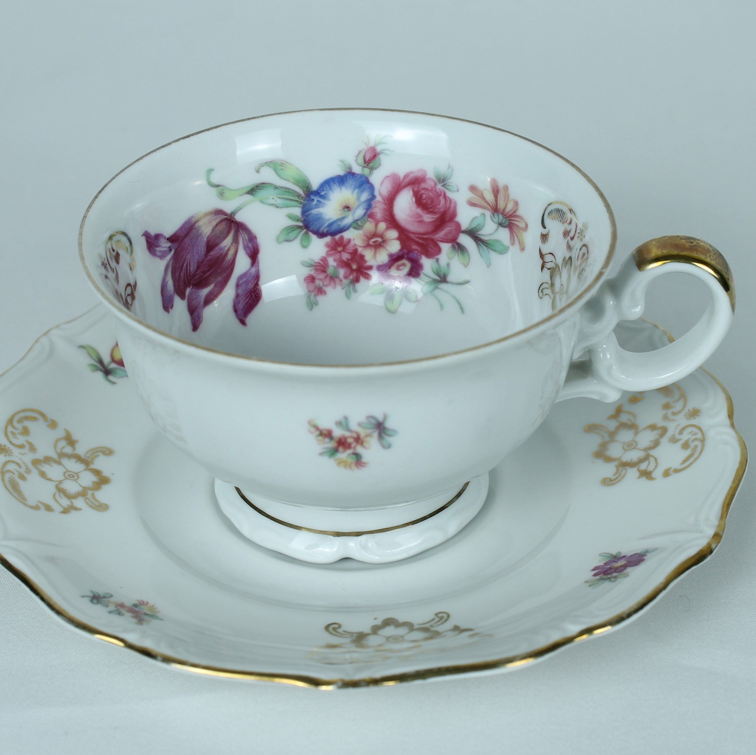Teacup and saucer with floral design on a white background