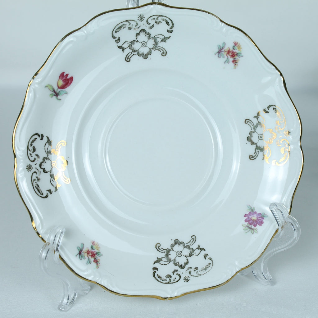 Decorative ceramic plate with floral patterns on a stand against a light background