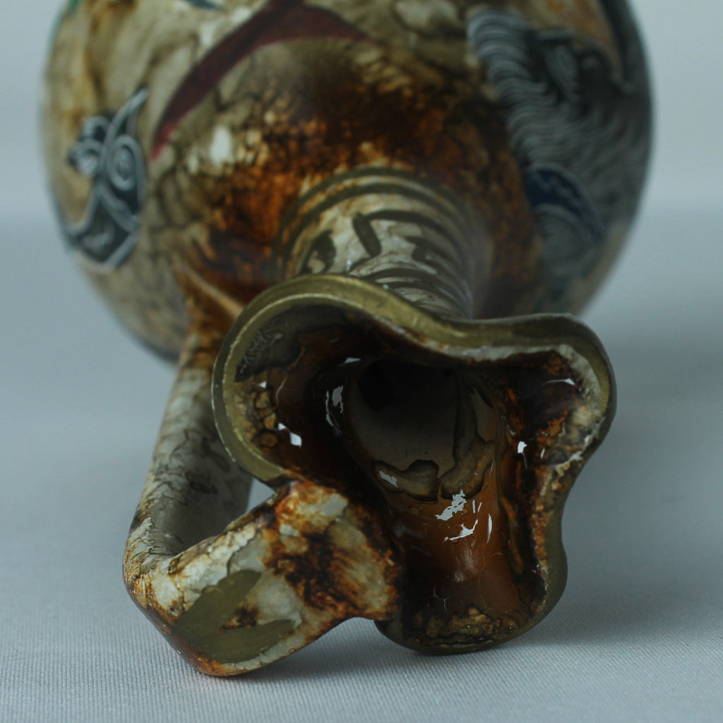 Close-up of a ceramic vase with intricate designs on a light gray background