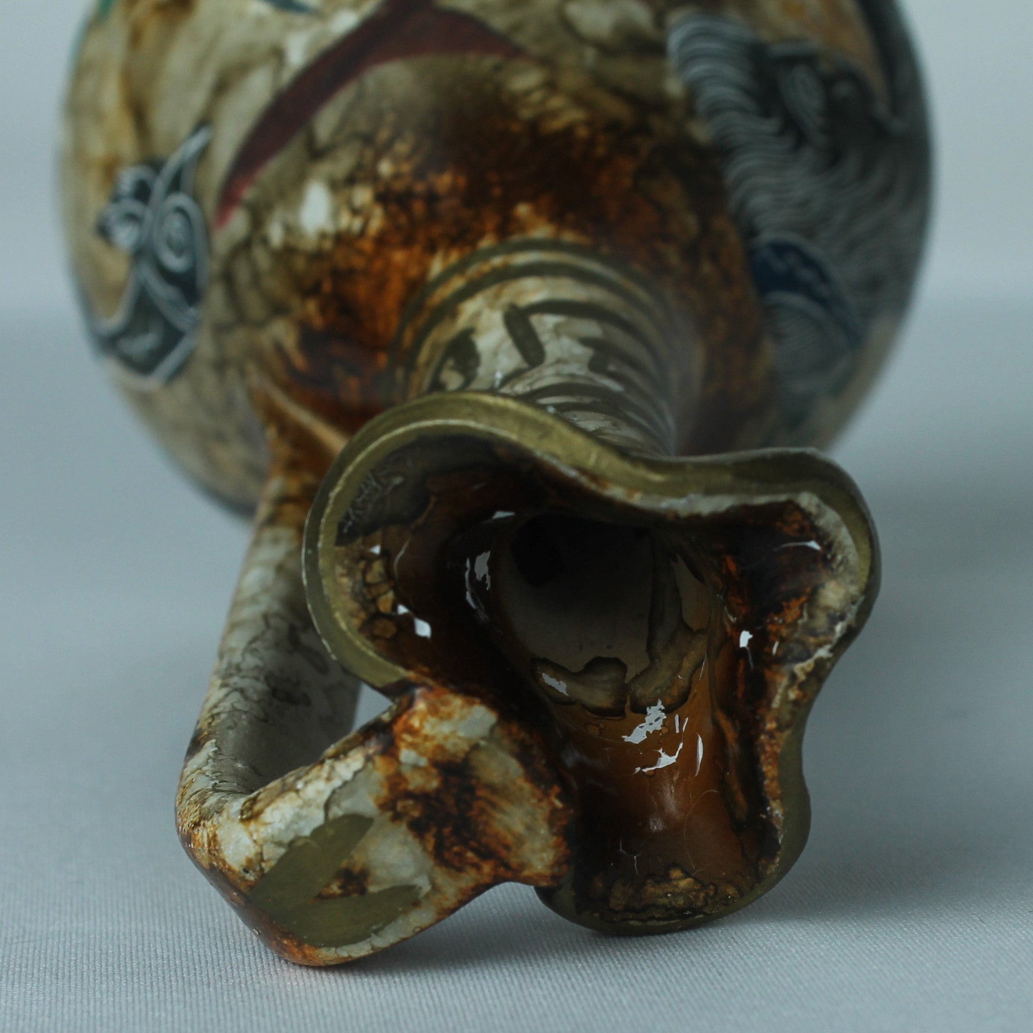 Close-up of a ceramic vase with intricate designs on a light gray background