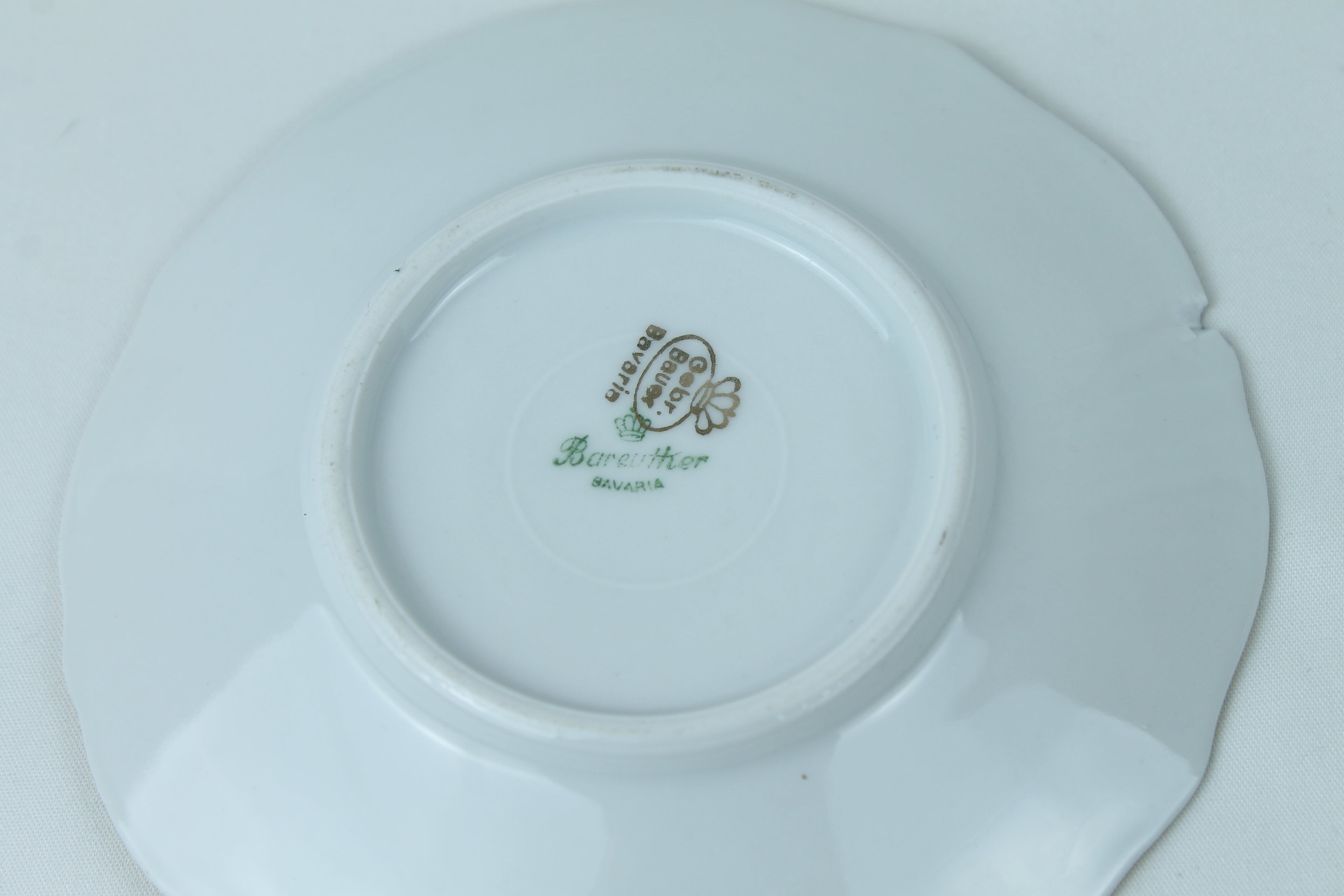 White ceramic plate with a visible brand logo on a white background