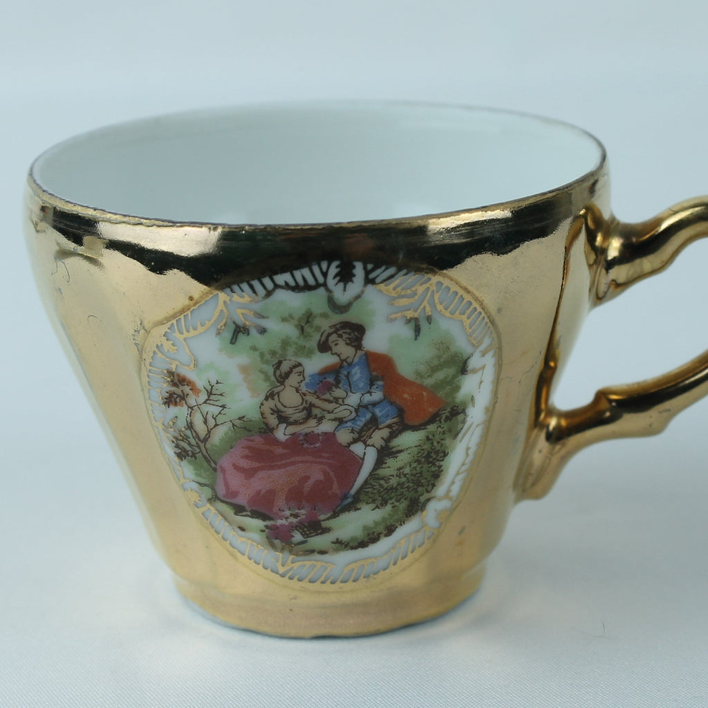 Decorative teacup with gold rim and handle on a white background