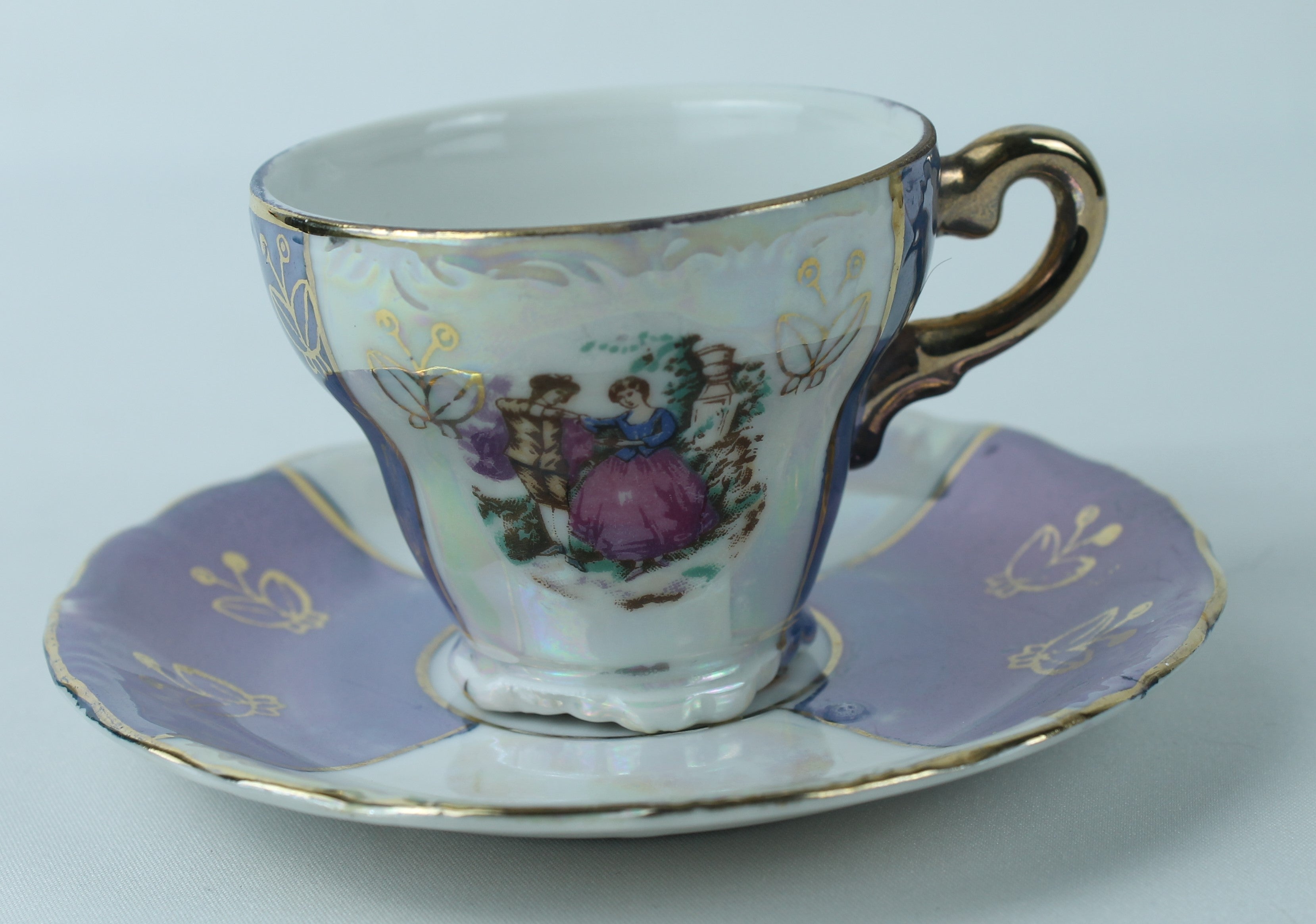 Kop en schotel met parelmoerglans en romantisch tafereel