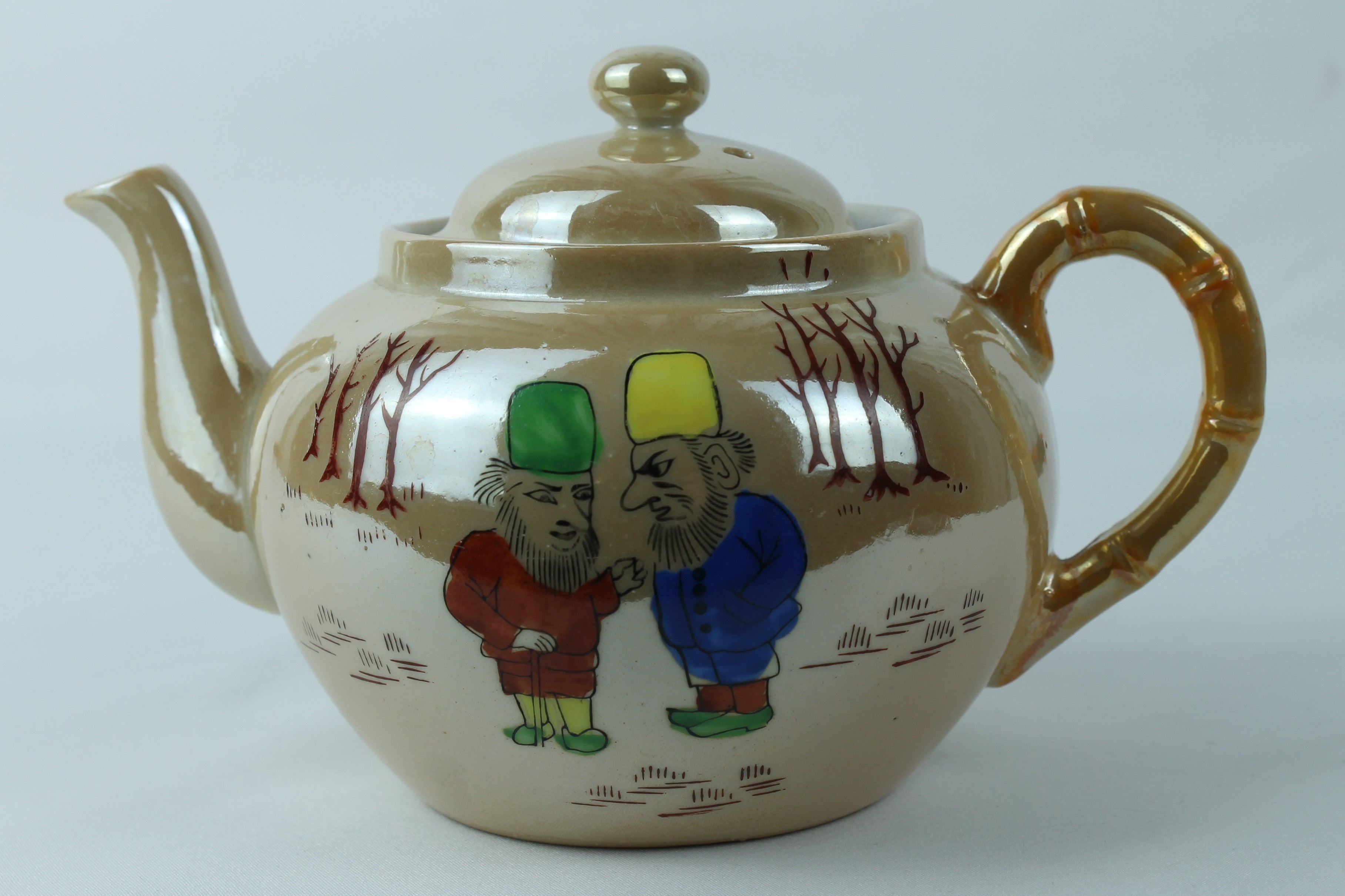 Teapot with cartoon characters on a plain background