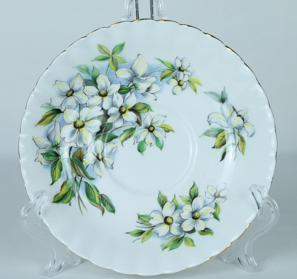 Decorative plate with floral design on a clear stand against a light gray background