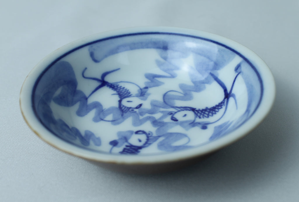 Petit bol bleu et blanc avec motif de poisson (±8 cm) – extérieur vitré marron
