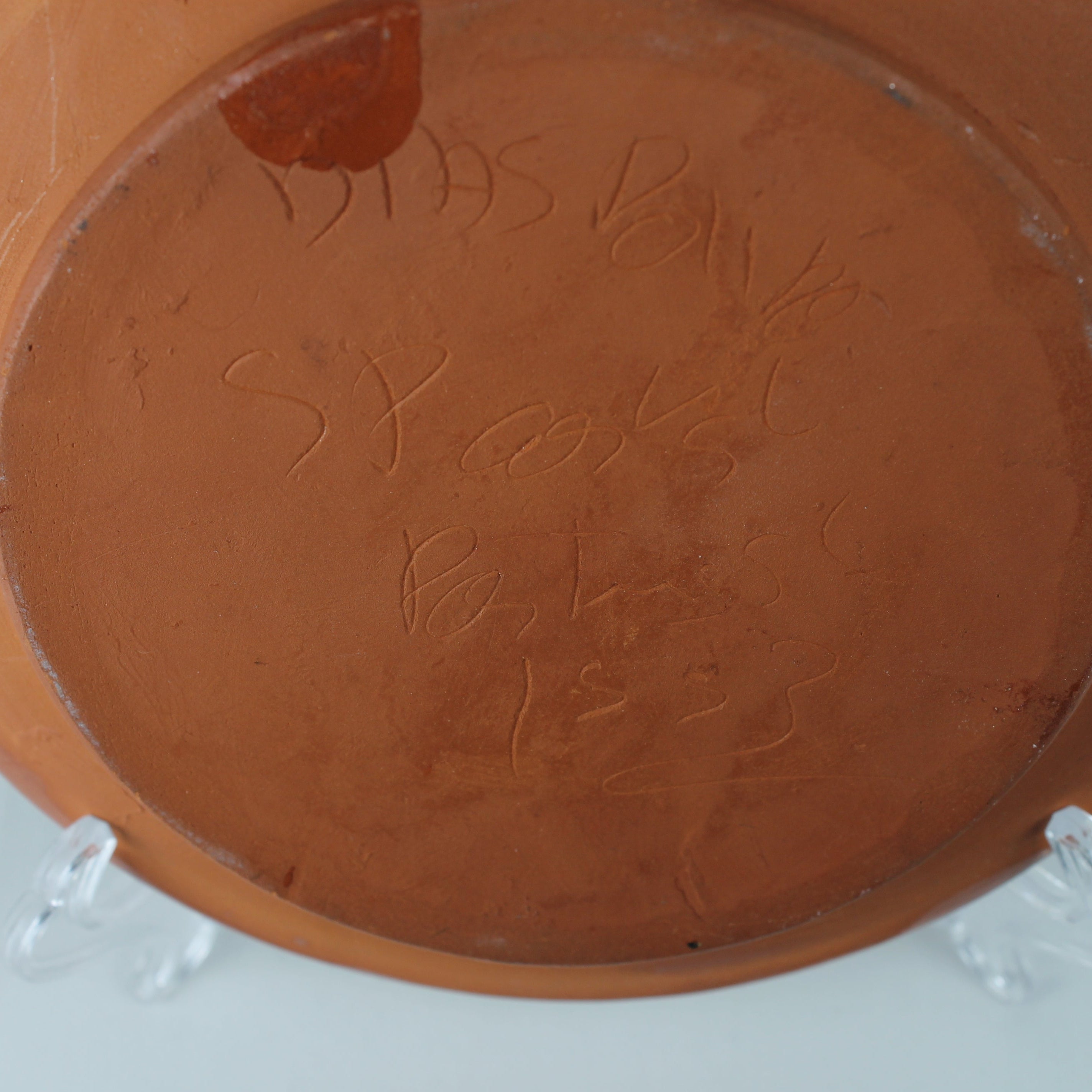 Terracotta pot with engraved text on a white background