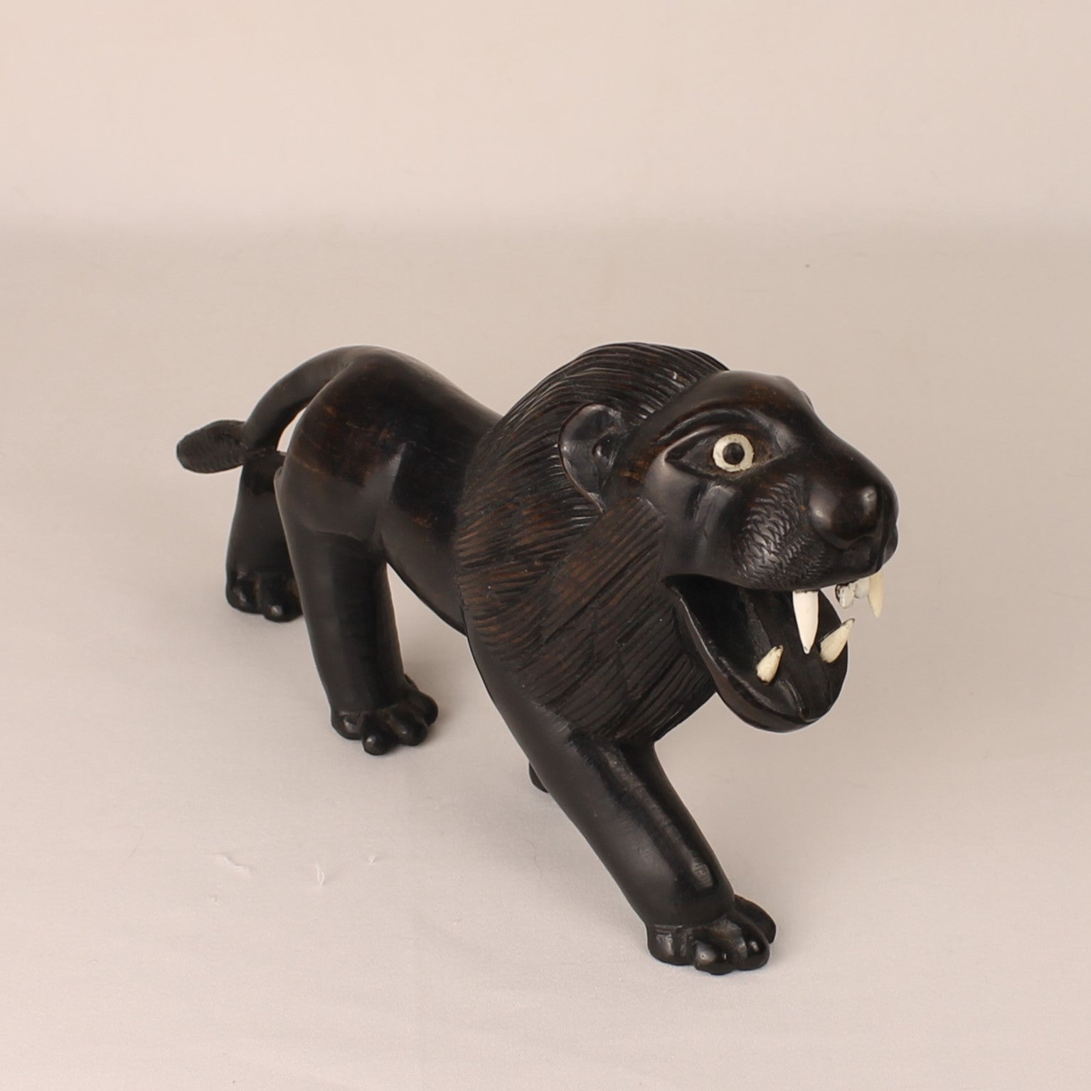 Black lion figurine on a beige background