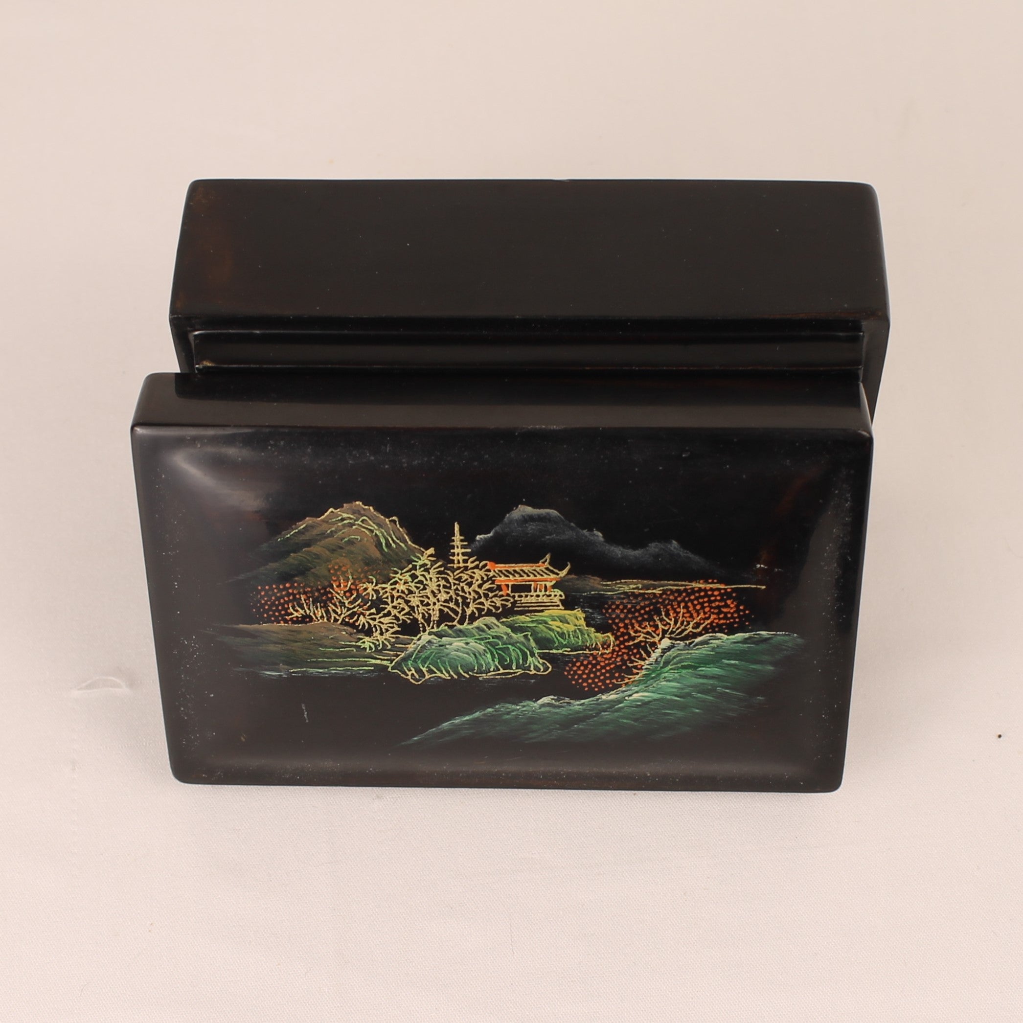 Black lacquer box with scenic engraving on a white background