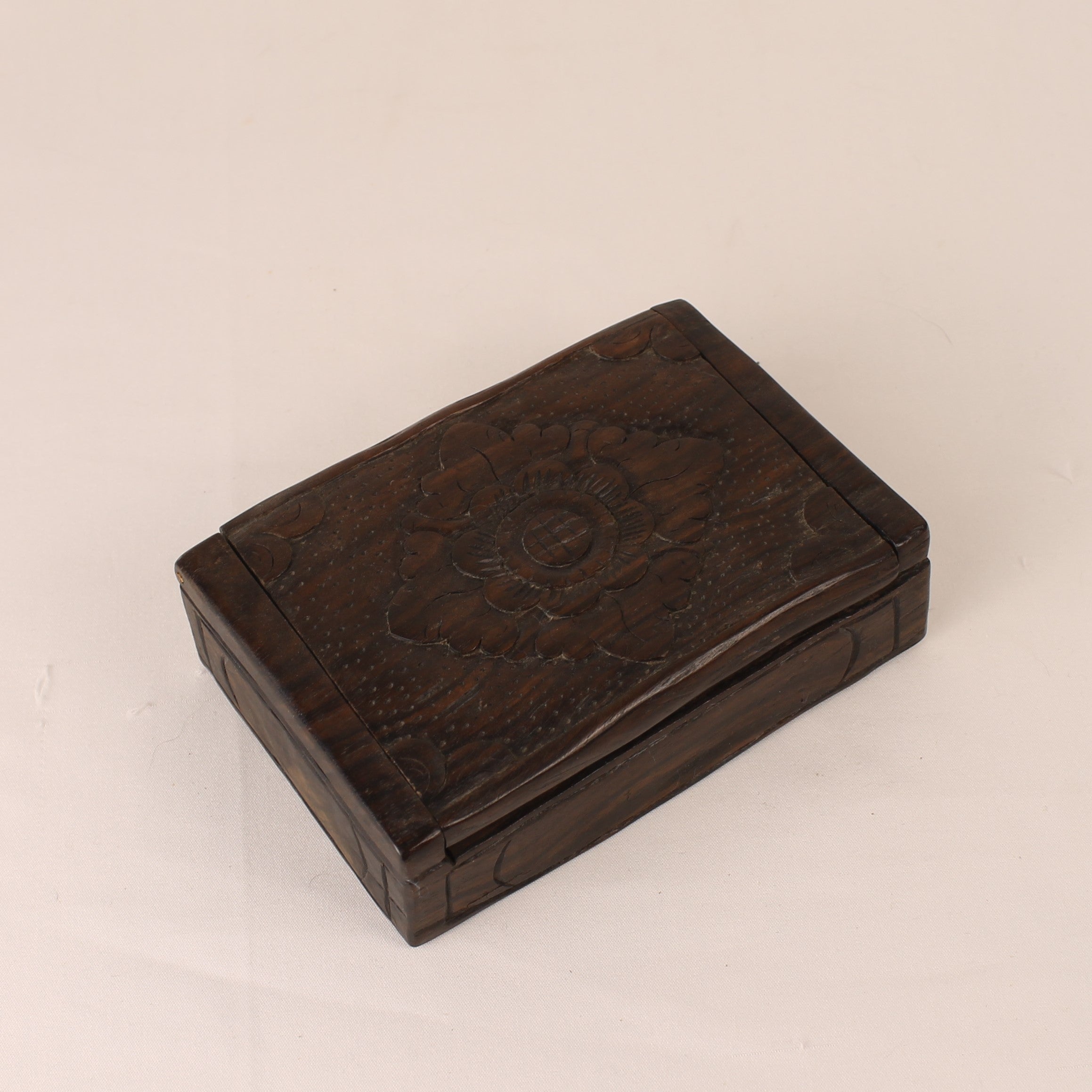 Wooden box with floral carvings on a beige background
