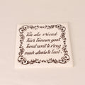 Square ceramic tile with decorative text and border on a beige background
