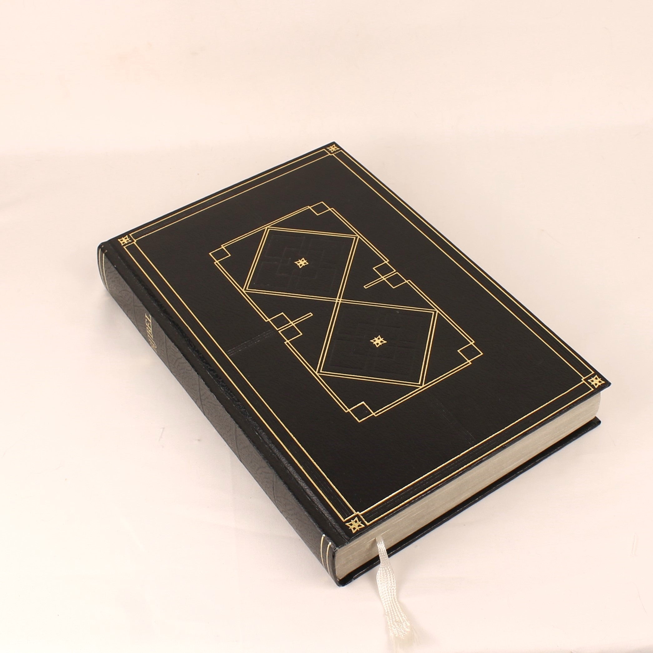Black book with gold decorative elements on a beige background