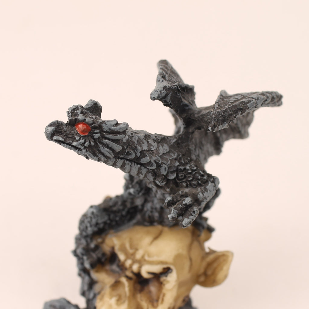 Dragon figurine with red eyes on a beige background