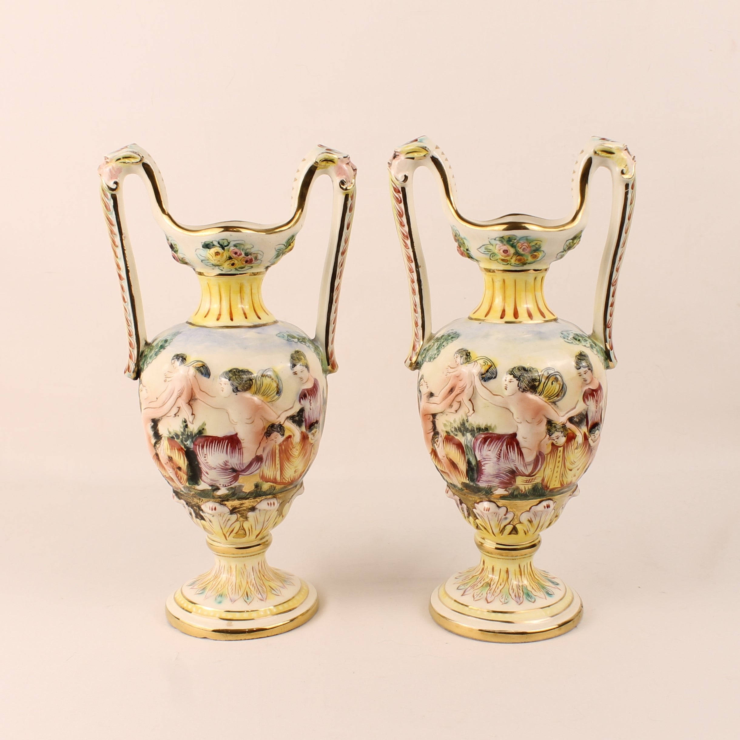 Pair of ornate vases with floral designs on a beige background