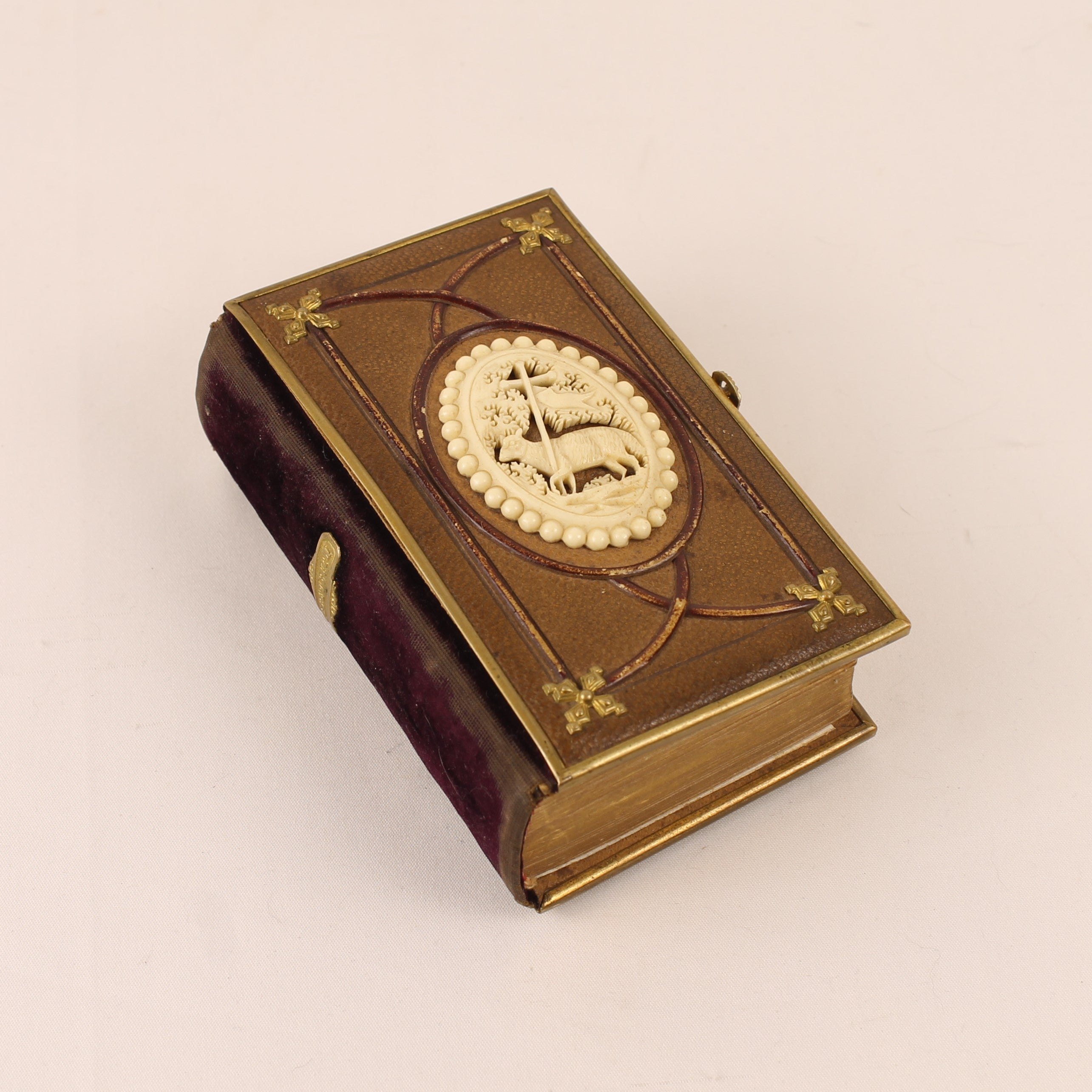 Decorative book with gold embossed cover on a beige background