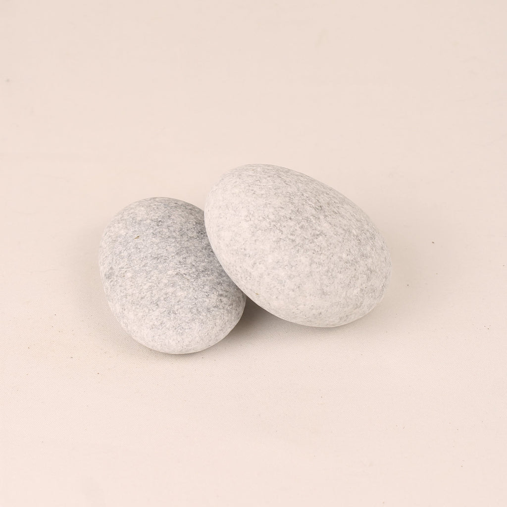 Two gray textured stones on a beige background