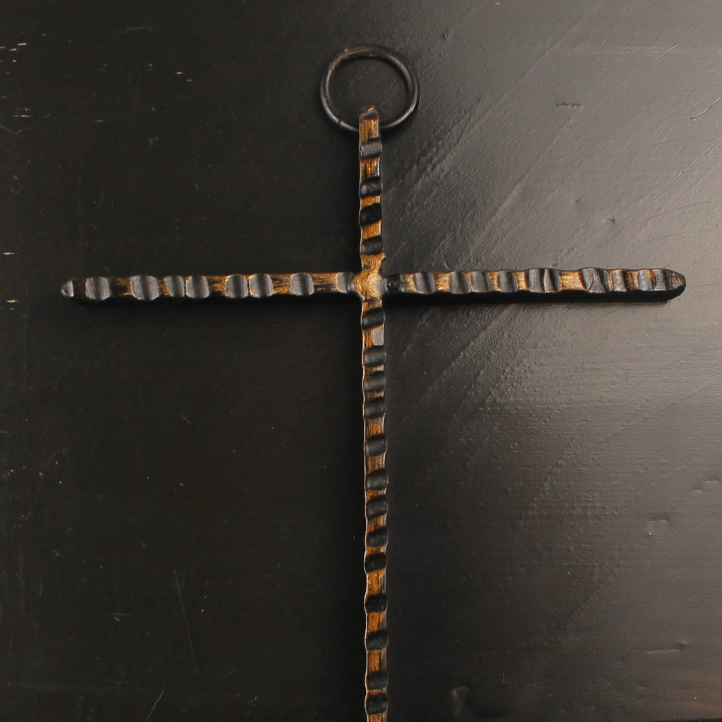 Decorative cross with a textured design on a dark surface