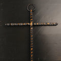 Decorative cross with a textured design on a dark surface