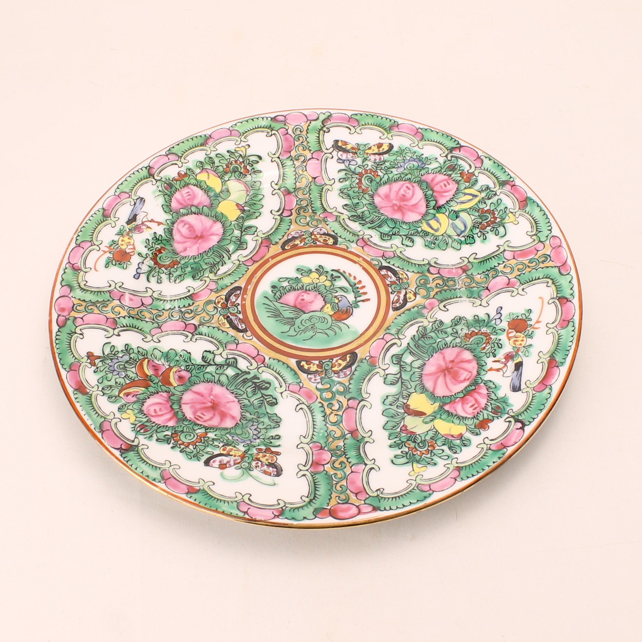 Decorative ceramic plate with intricate floral and paisley patterns on a beige background