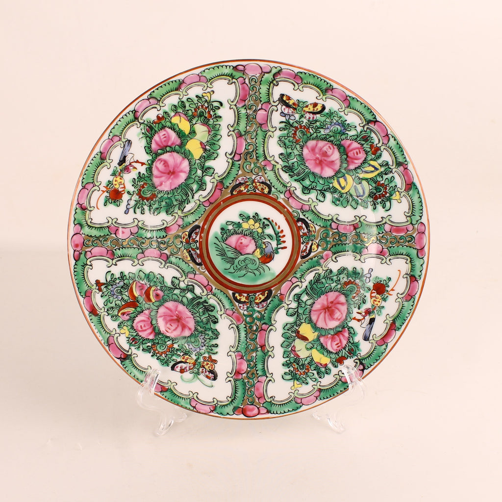 Decorative ceramic plate with floral and bird patterns on a beige background