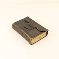 Vintage-style leather-bound book with a flap on a white background