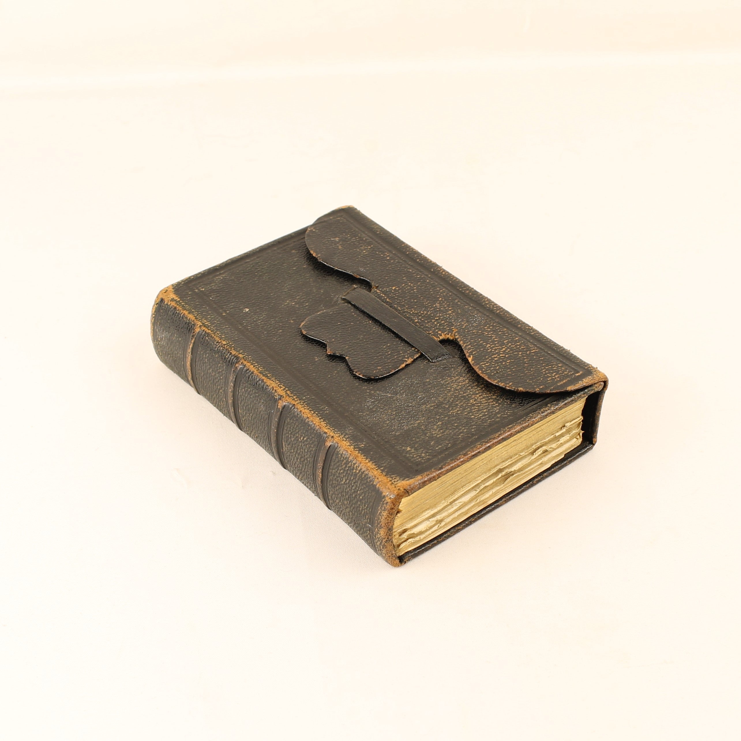 Vintage-style leather-bound book with a flap on a white background
