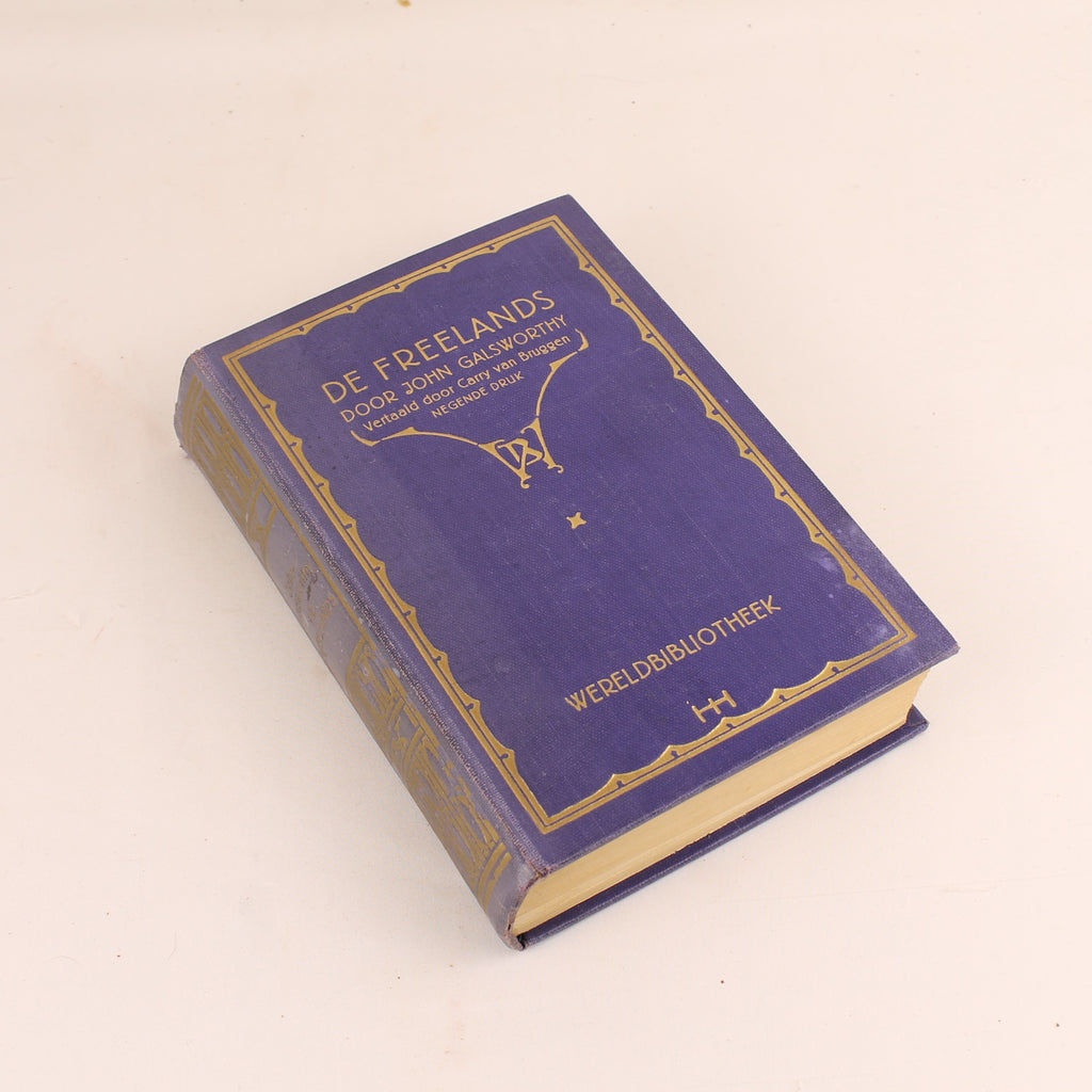 Vintage blue book with gold detailing on a beige background