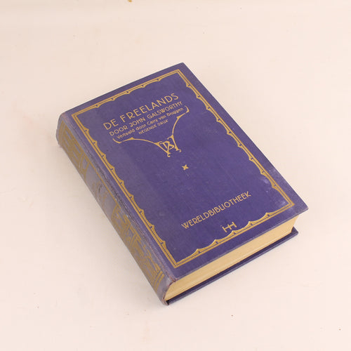 Vintage blue book with gold detailing on a beige background
