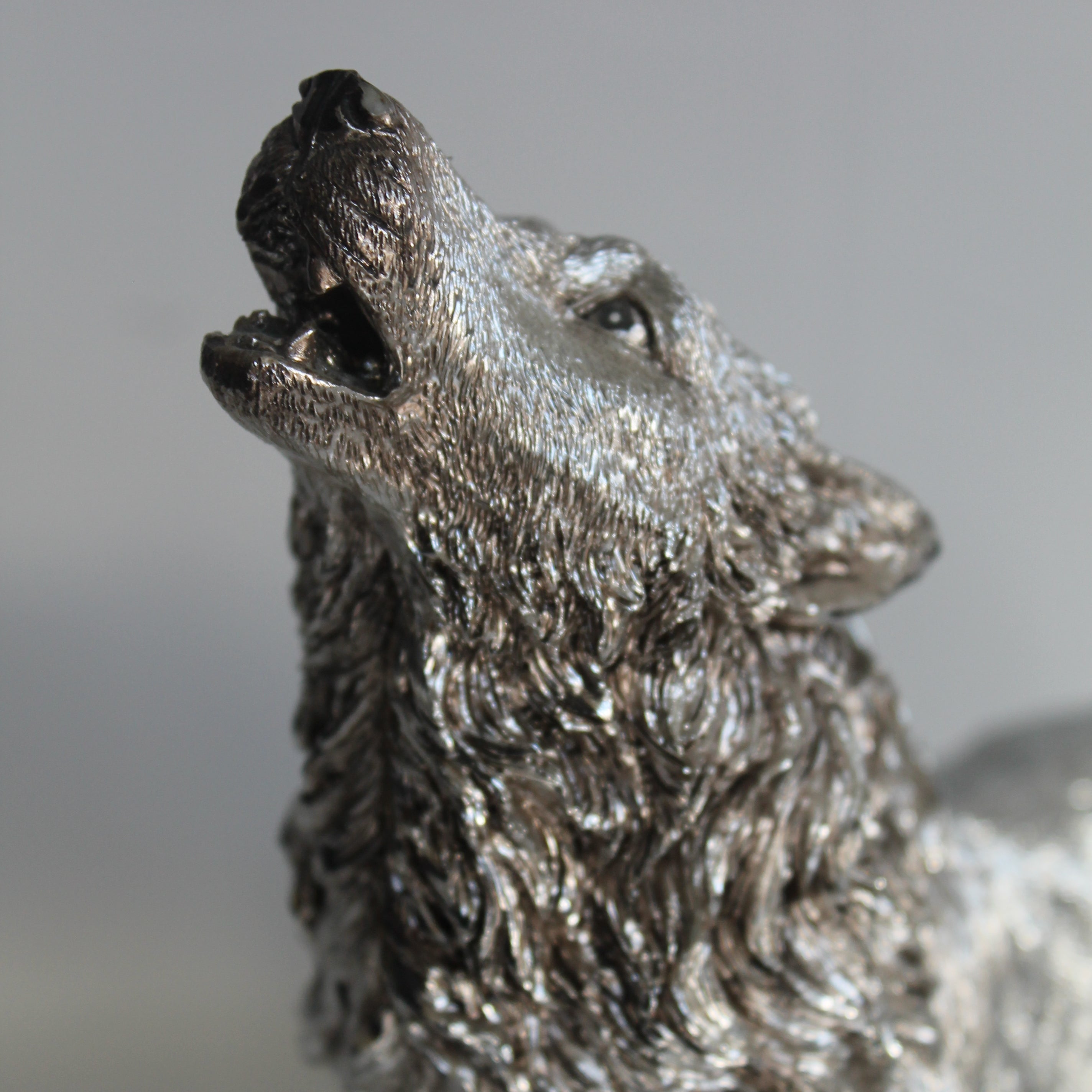 Metallic wolf figurine on a gray background