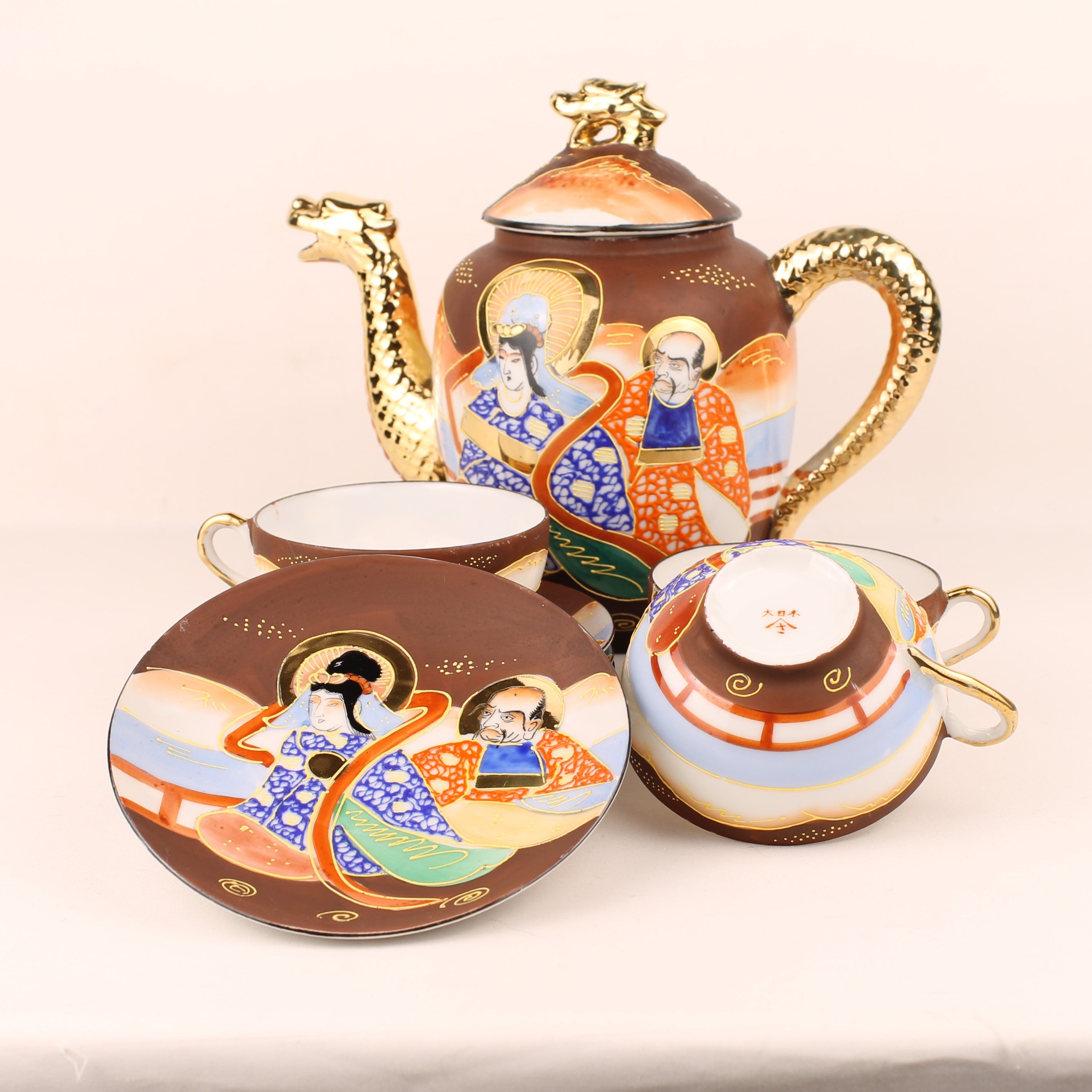 Decorative teapot set with artistic designs on a beige background