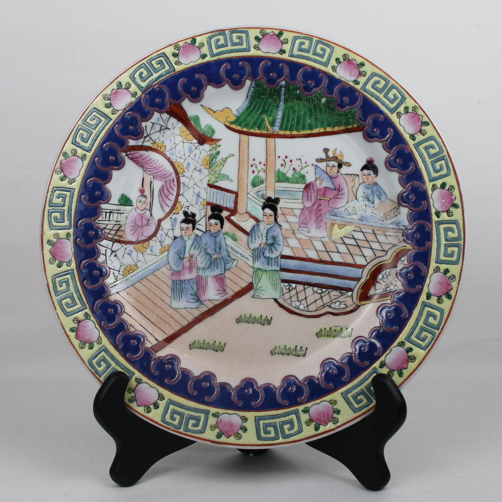 Decorative ceramic plate with traditional design on a stand against a white background