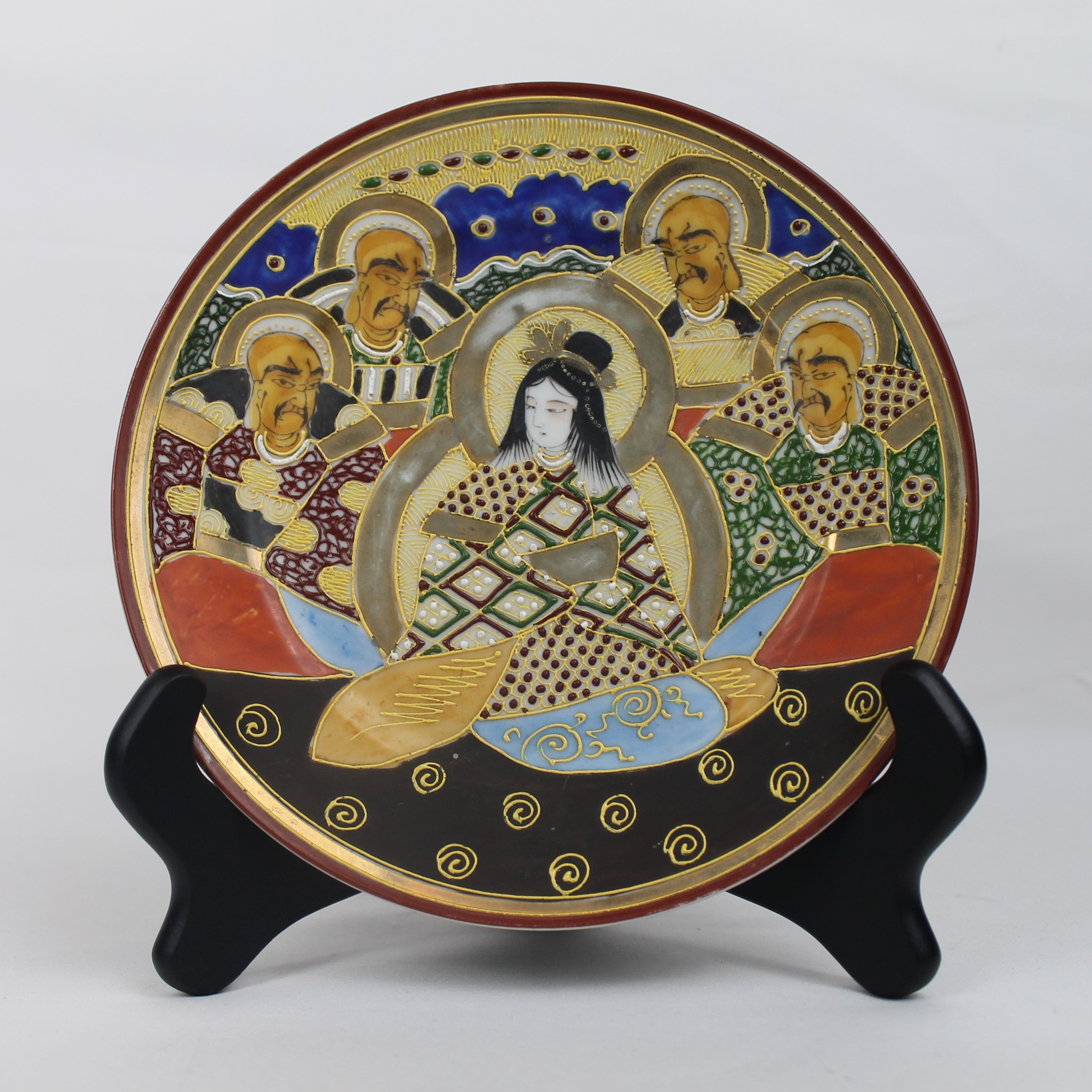 Decorative plate with artistic design on a stand against a white background