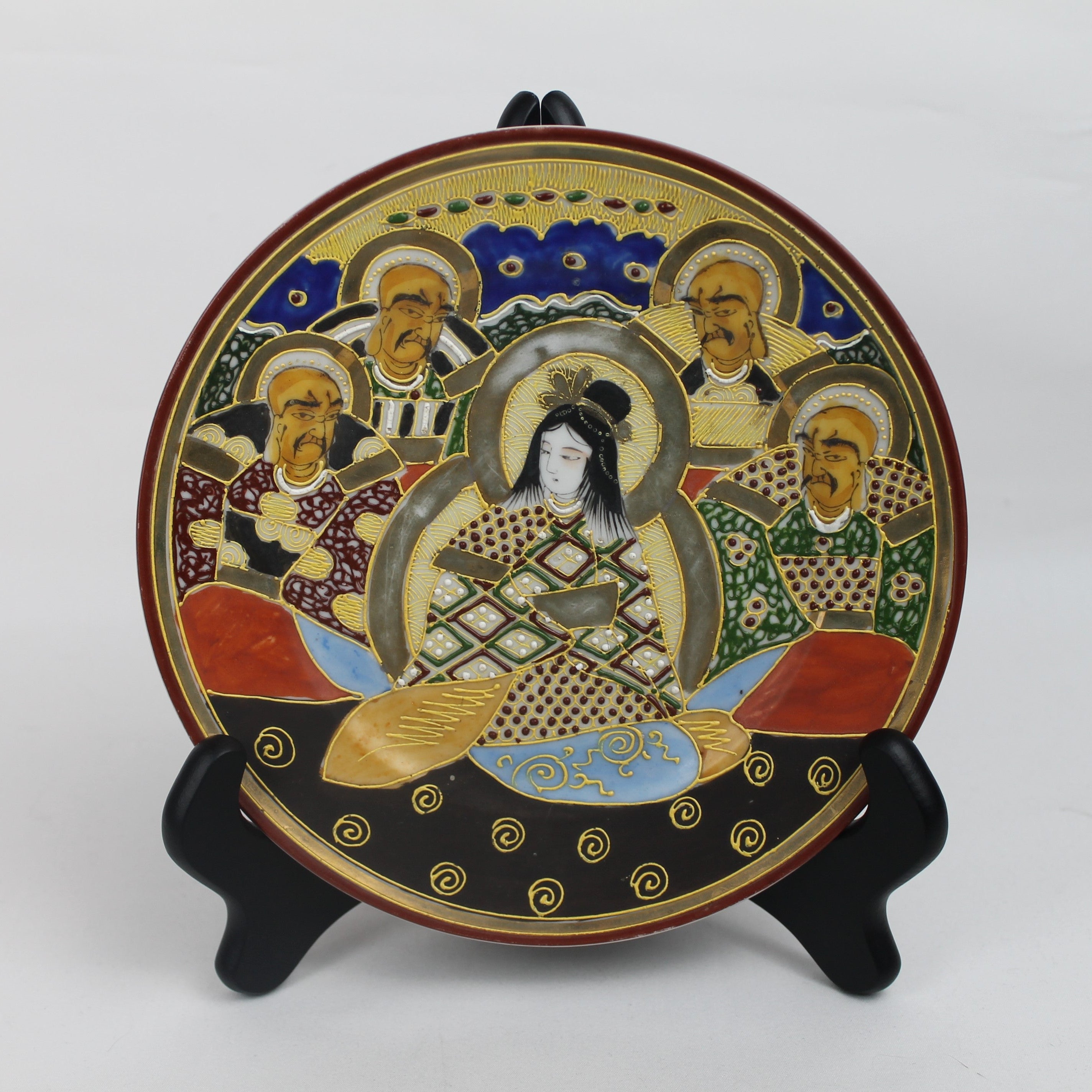 Decorative plate with artistic design on a stand against a white background