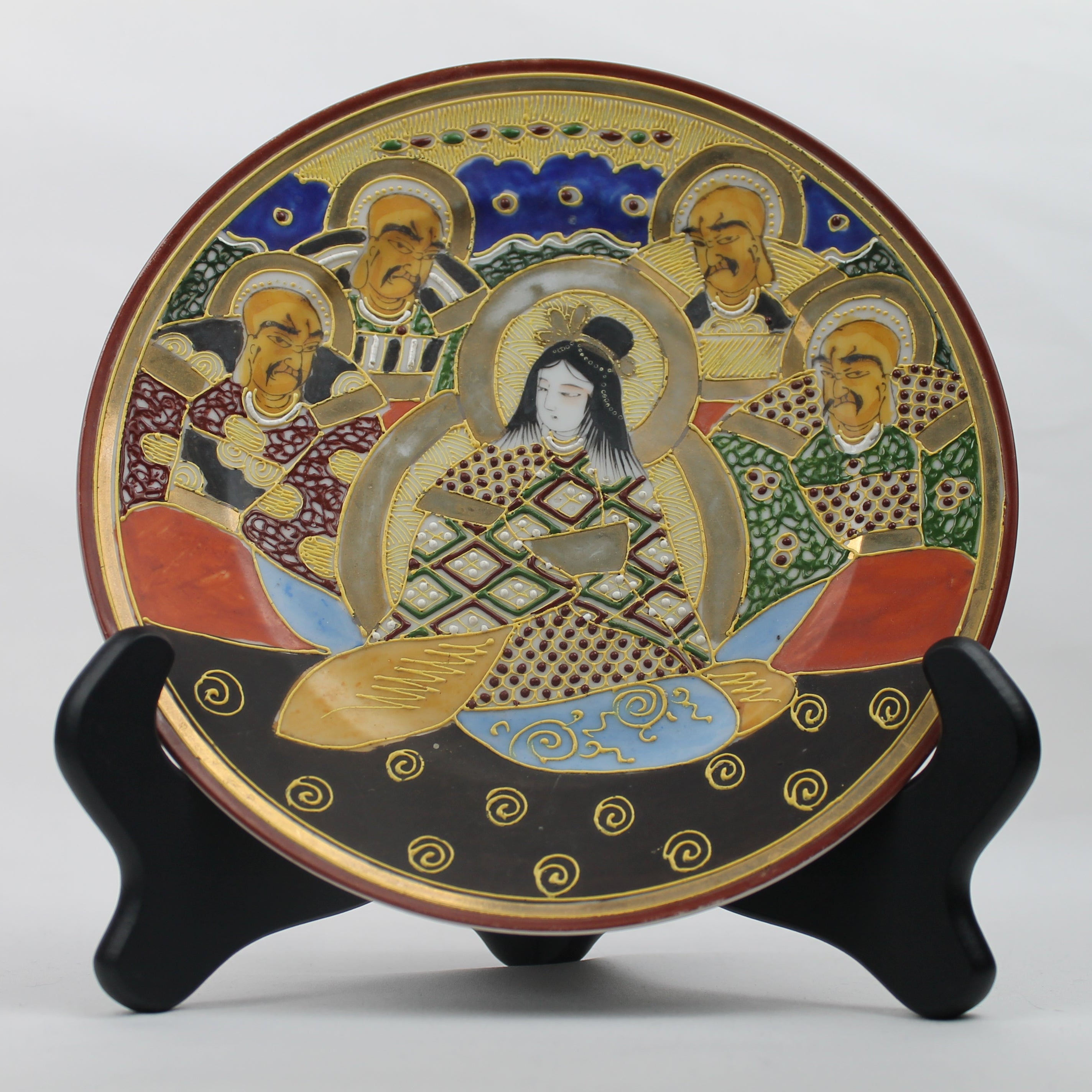 Decorative plate with artistic design on a stand against a white background