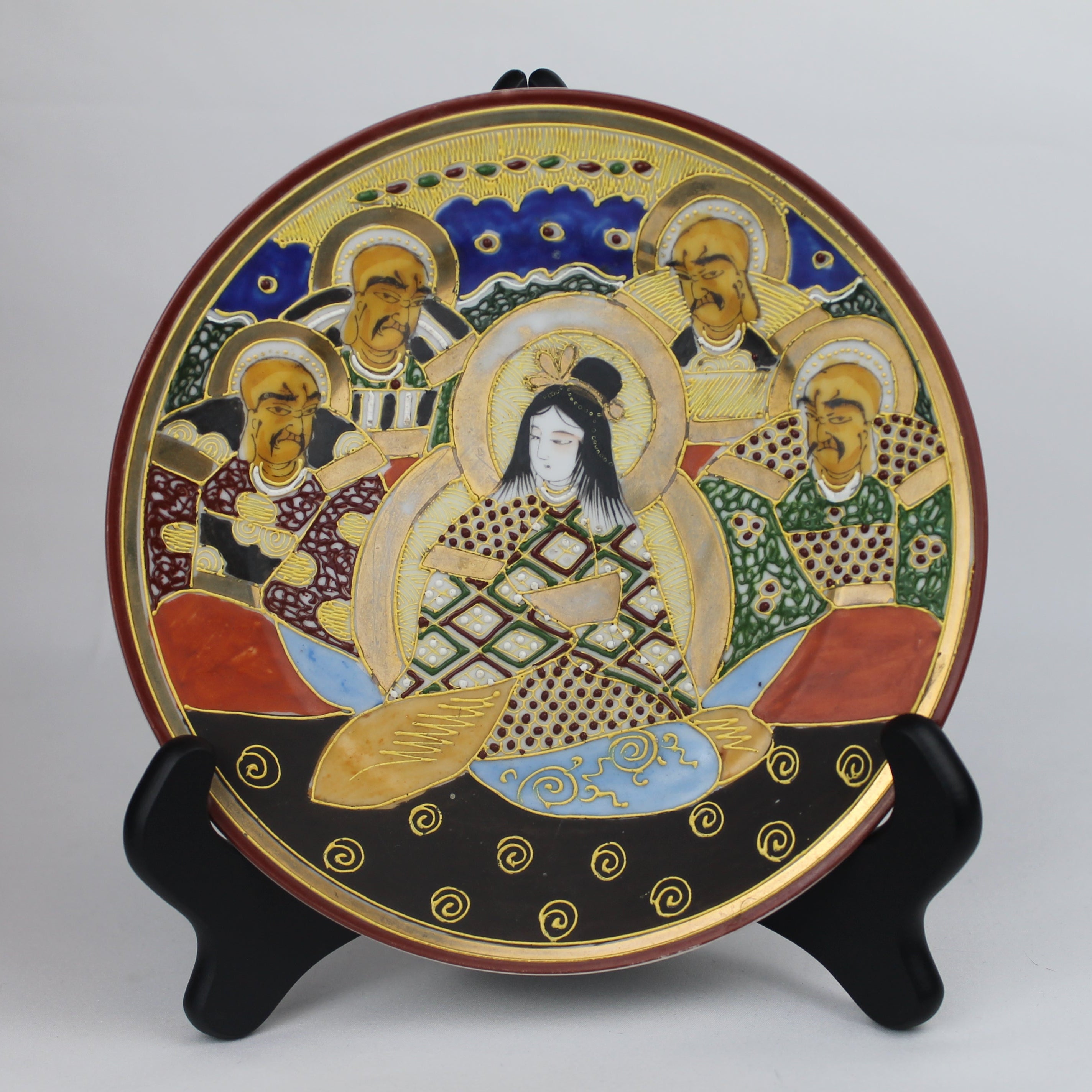 Decorative plate with artistic design on a stand against a gray background