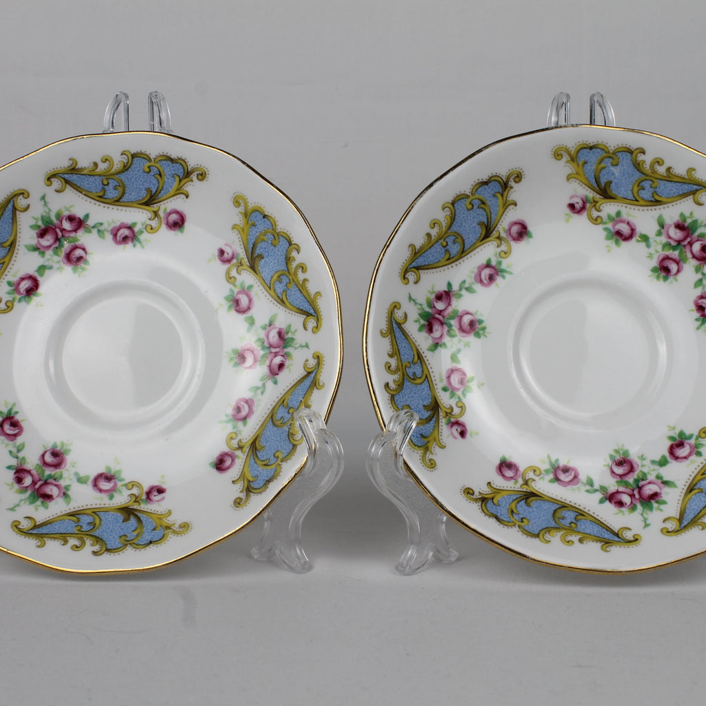 Two decorative ceramic saucers with floral patterns on a gray background