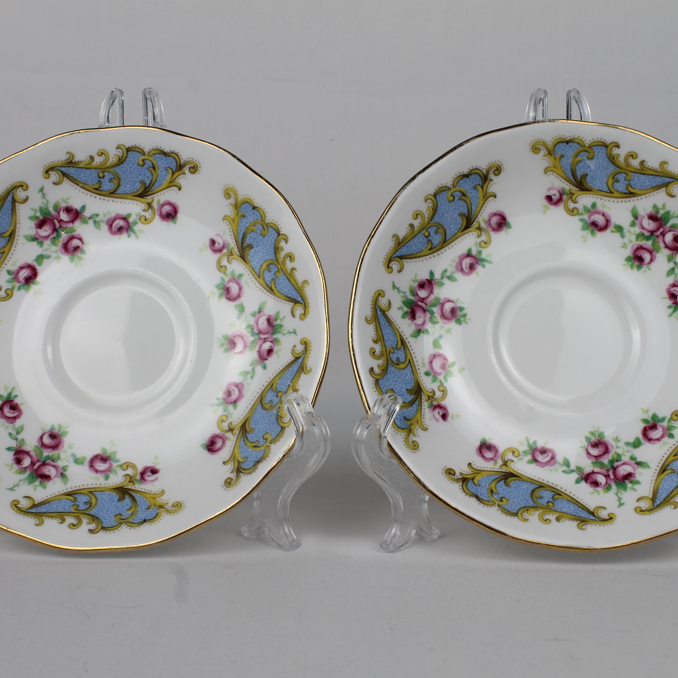 Two decorative ceramic saucers with floral patterns on a gray background