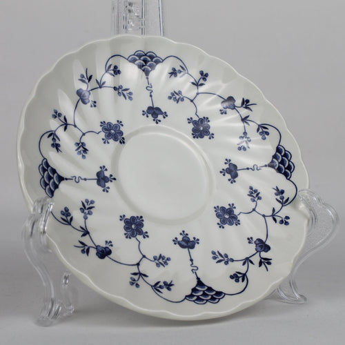 White ceramic plate with blue floral patterns on a clear stand against a gray background