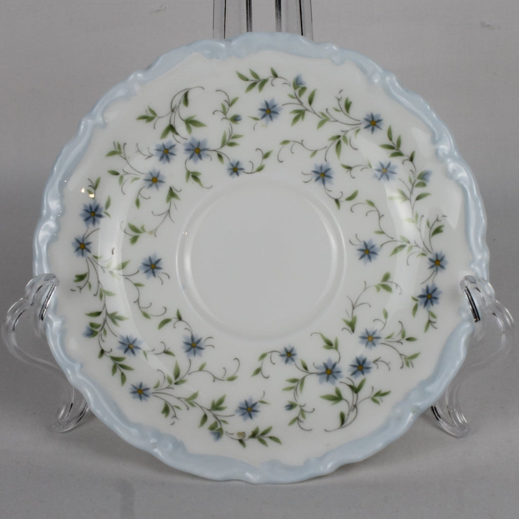 Decorative ceramic plate with floral pattern on a stand against a gray background
