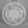 Decorative ceramic plate with floral pattern on a stand against a gray background