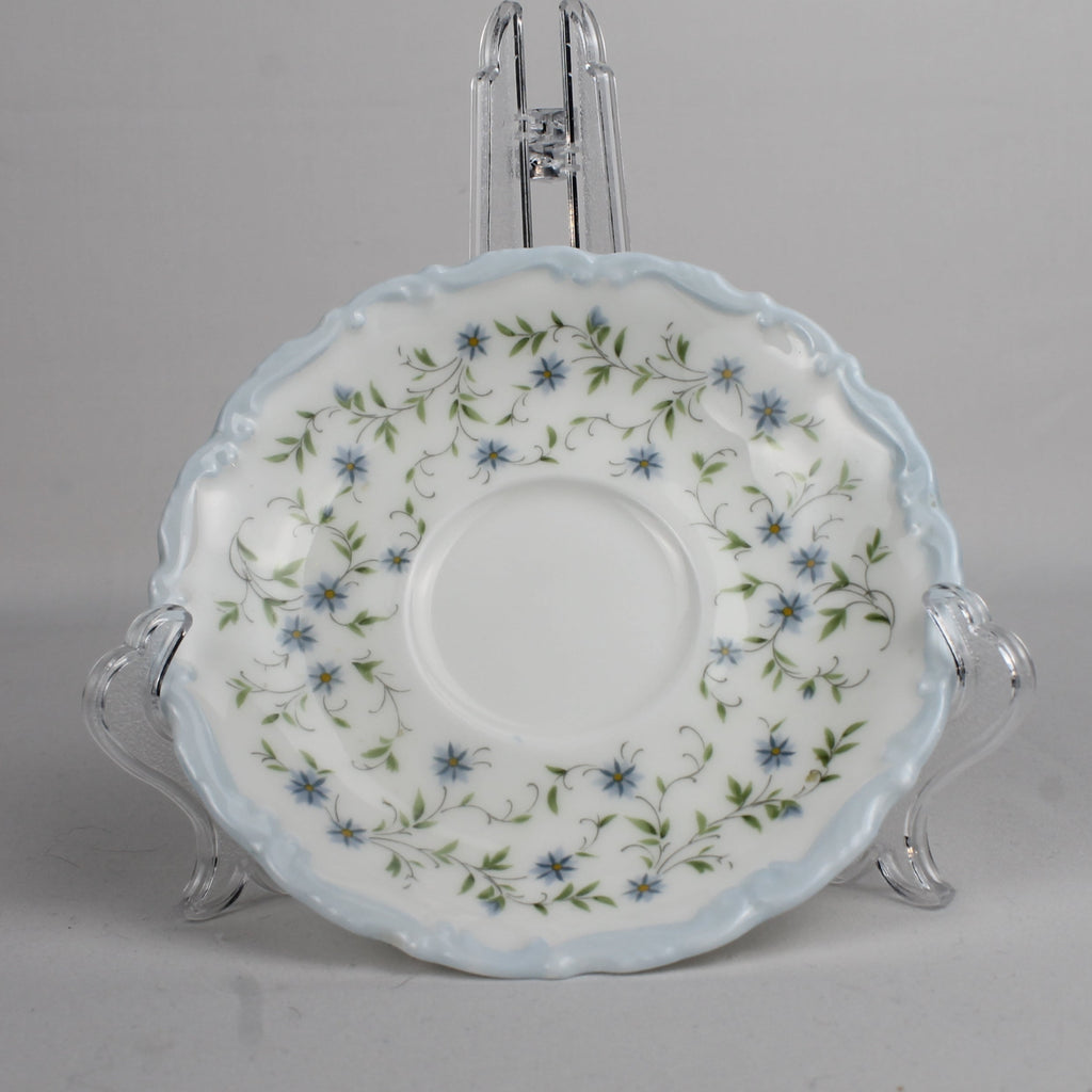 Decorative ceramic saucer with floral pattern on a gray background
