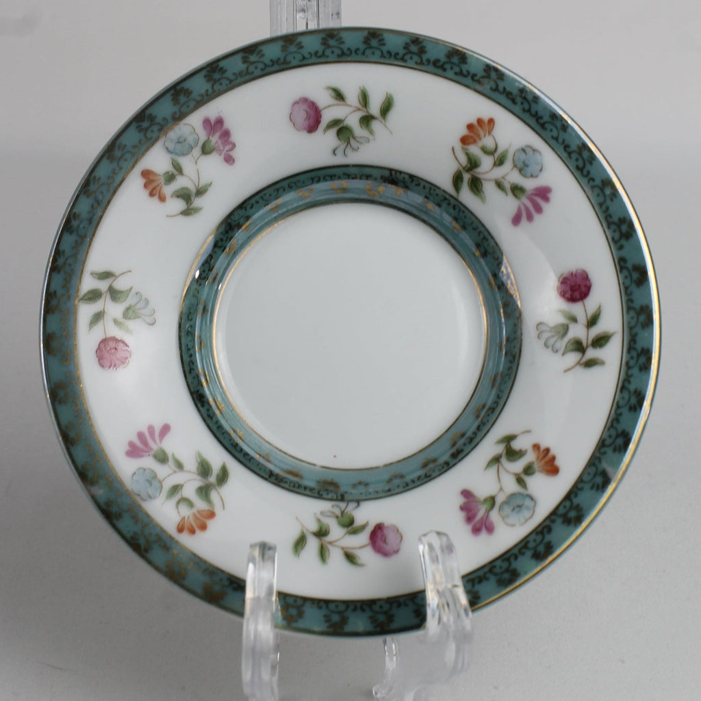 Decorative plate with floral patterns on a stand against a white background