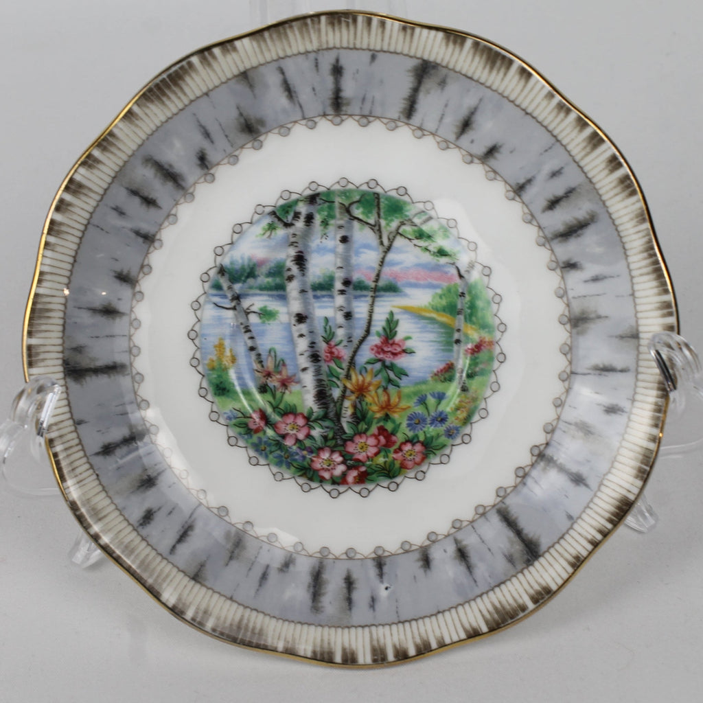 Decorative plate with floral and landscape design on a white background