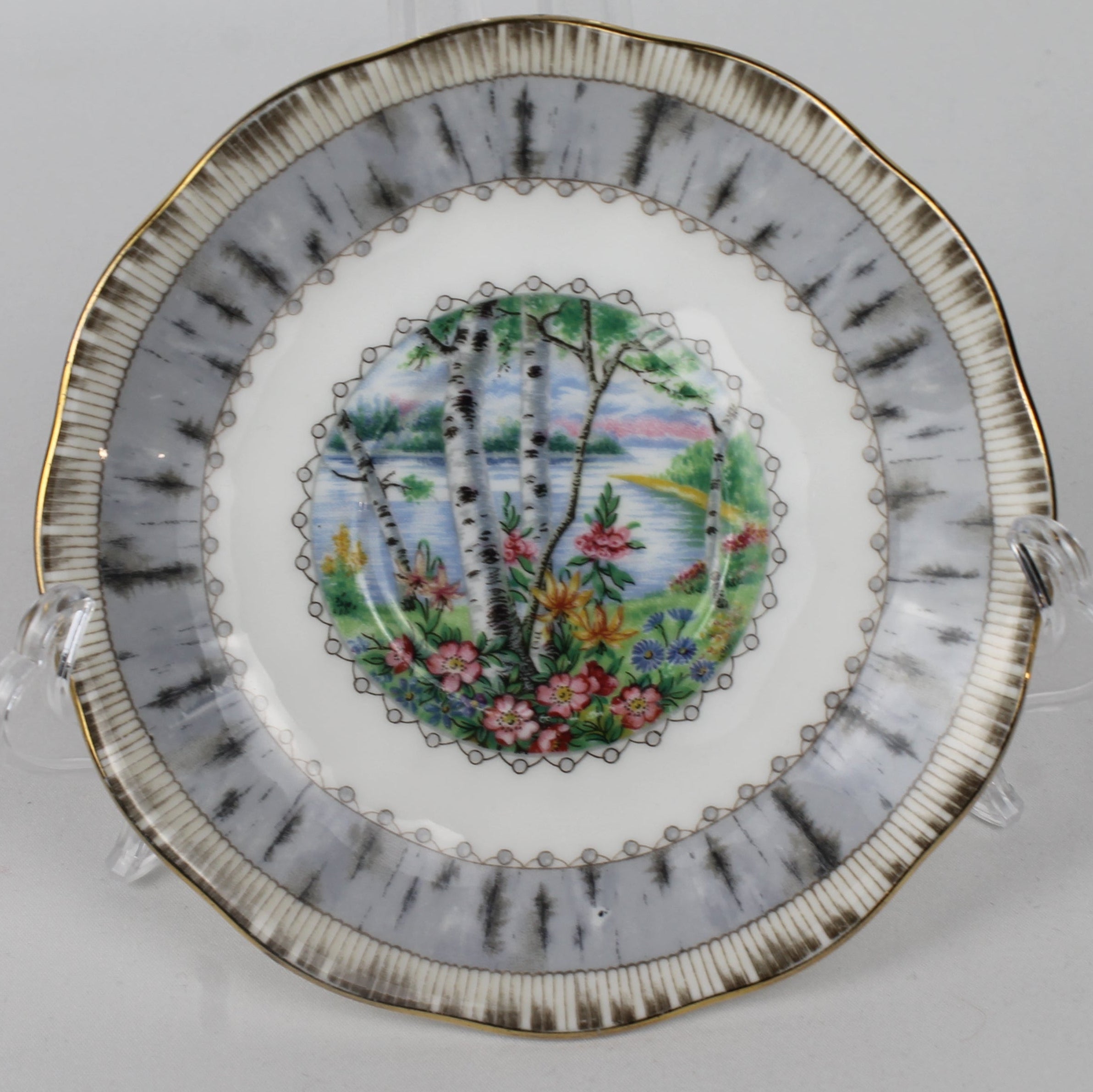 Decorative plate with floral and landscape design on a white background