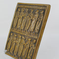 Bronze plaque with engraved figures on a white background