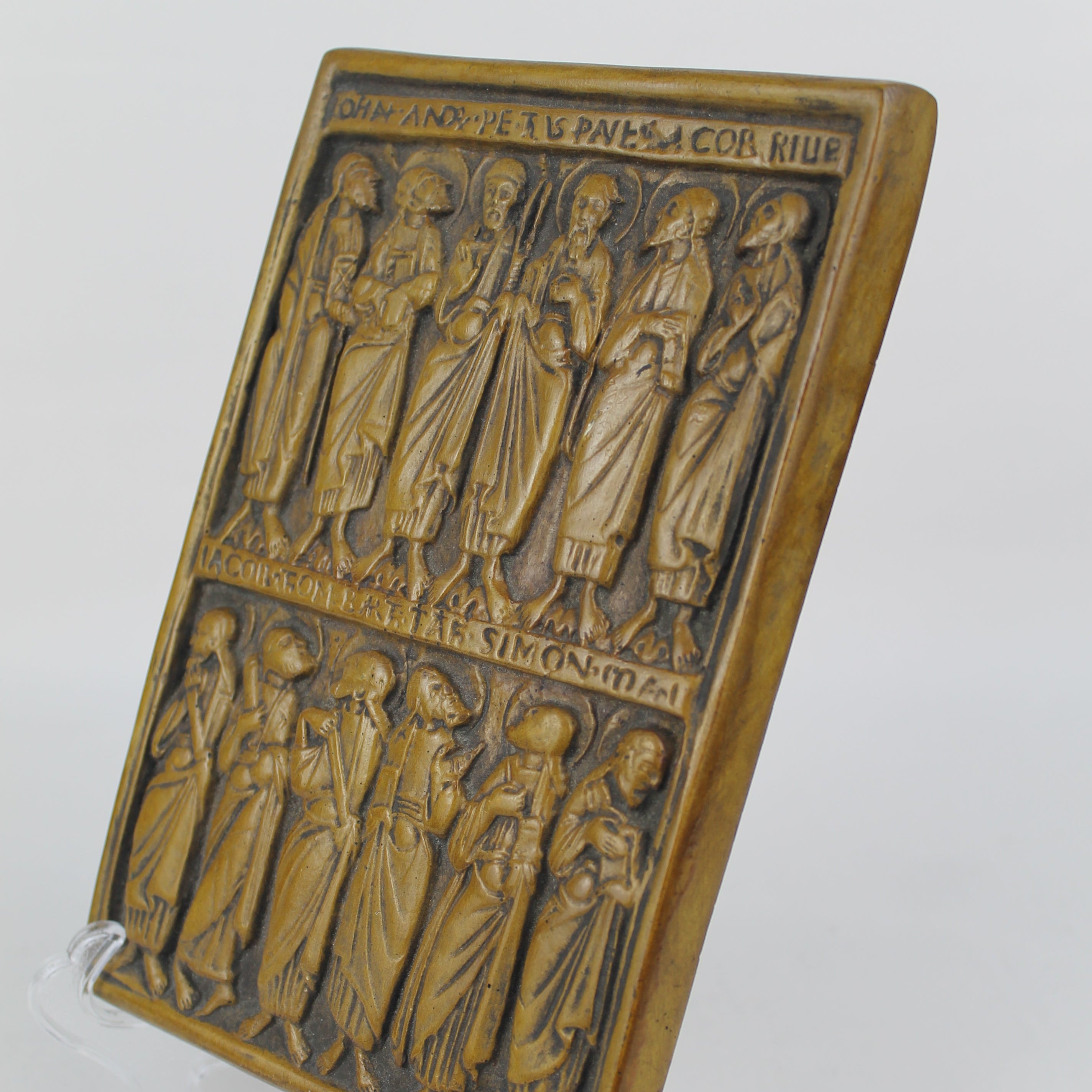 Bronze plaque with engraved figures on a white background