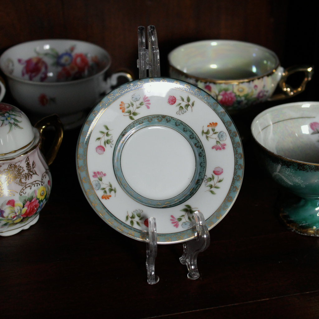 Collection of decorative teacups and saucers on a dark surface